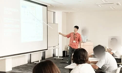 琉球銀行のセミナーでスクリーンを指しながら解説する村山創
